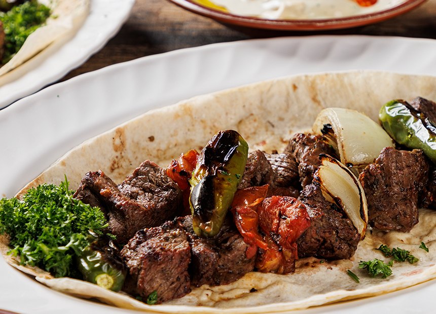 Grilled filet tips over pita with grilled tomato and onion